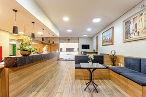 A modern hotel lobby with a reception desk, seating area, and artwork on the walls. - Daher Center Hotel (São Paulo)