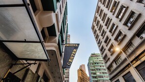 Un cartello con la scritta "HOTEL CENTER" circondato da alti palazzi.