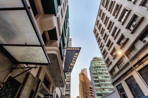 Une enseigne d’hôtel sur laquelle on peut lire « HÔTEL CENTER », entourée de grands immeubles.