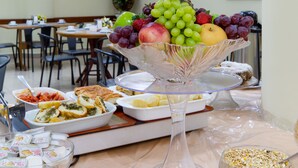Zona pranzo con una ciotola di frutta, diversi piatti e un'area buffet.