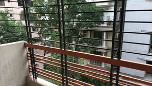 A balcony with metal railings and a view of neighboring buildings and trees. - Uttara Suite At Dhaka (Dhaka)