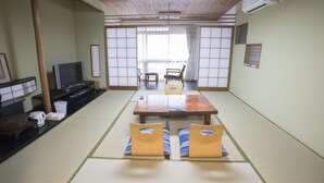 A traditional Japanese room with tatami flooring, a low table, and cushions. - Atami Kinomiyanoyu Shogetsu (Atami)