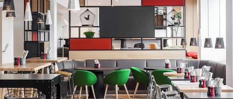 A modern interior with a mix of seating options, including tables and chairs, and a central seating area with a sofa and chairs.