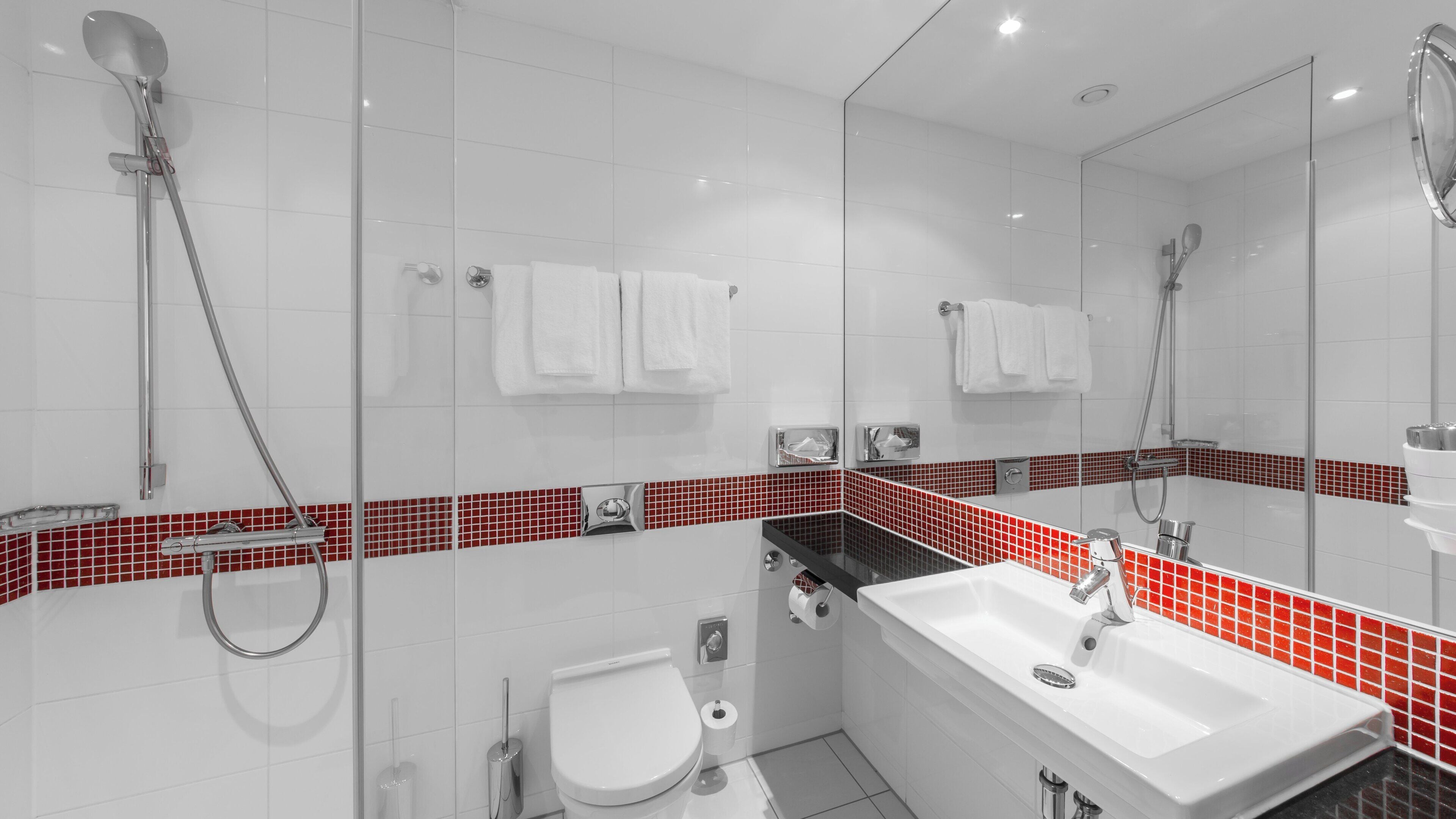 A modern bathroom with a shower, toilet, and sink.