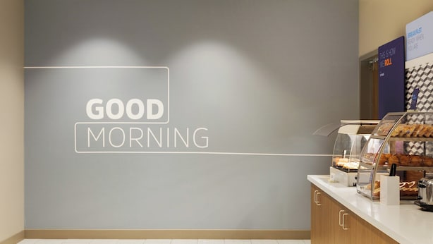 A breakfast counter with a sign that reads "GOOD MORNING" and a display case with pastries. - Holiday Inn Express & Suites Salem North - Keizer by IHG (Keizer)