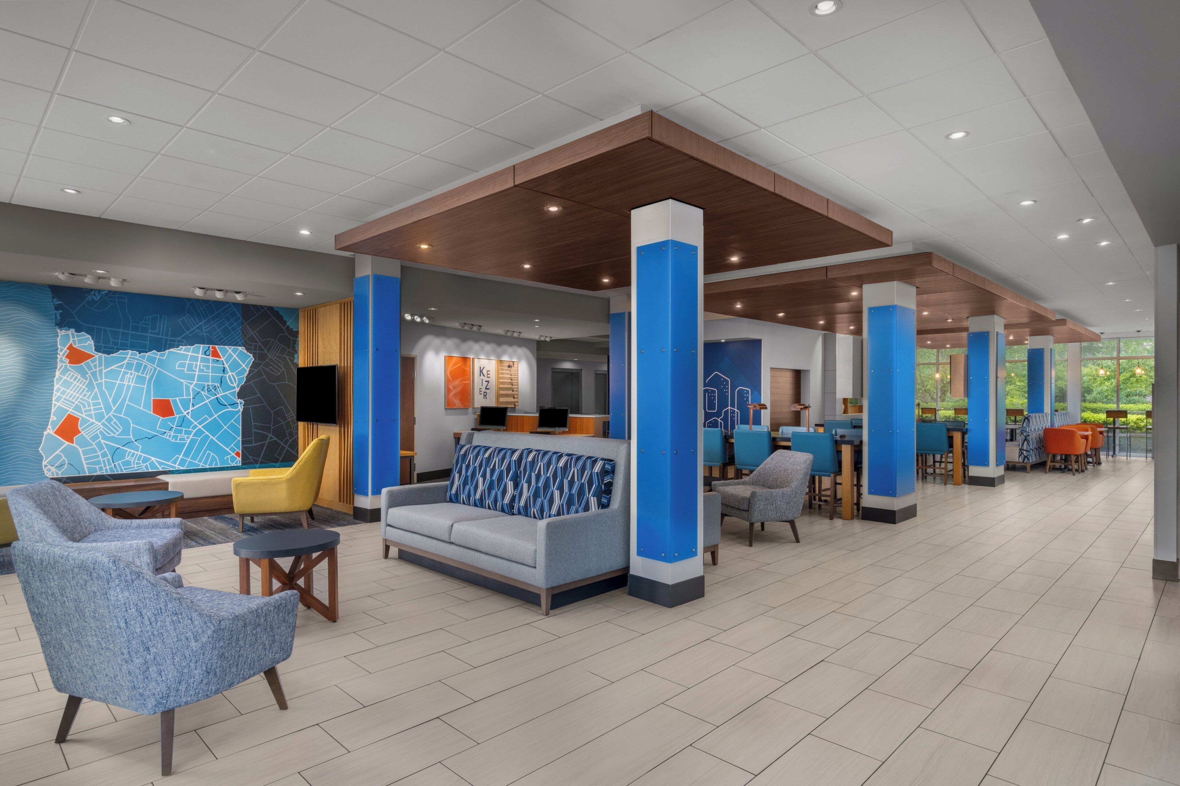 A spacious lobby with seating areas, a reception desk, and a large wall map.