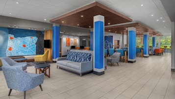 A spacious lobby with seating areas, a reception desk, and a large wall map.