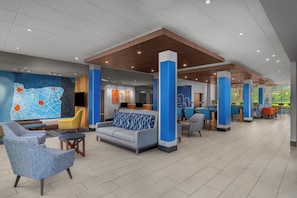 A spacious lobby with seating areas, a reception desk, and a large wall map.