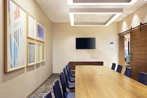 A conference room with a long table, blue chairs, a flat-screen TV, and framed artwork on the wall. - Holiday Inn Express & Suites Salem North - Keizer by IHG (Keizer)