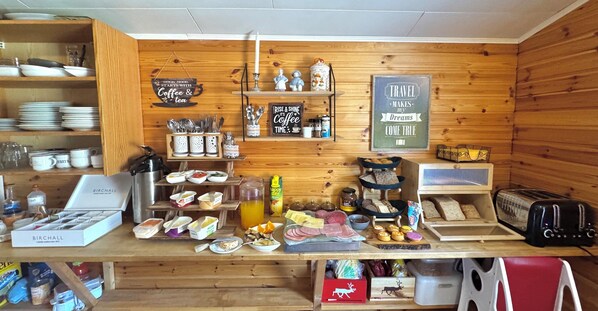 A breakfast bar with a variety of food items and a coffee station.