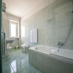 A bathroom with a bathtub, toilet, and sink.