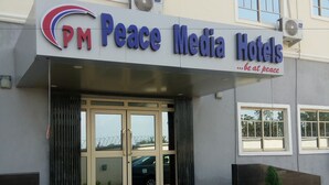 L’extérieur des hôtels PM Peace Media se caractérise par une entrée moderne, de grandes fenêtres et un ciel dégagé.