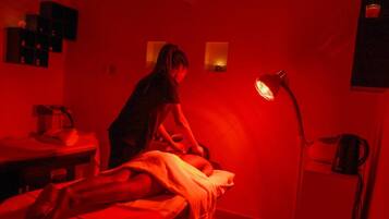 Relax in a serene space with a massage table and comfortable seating area.