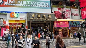 A busy street with various shops and a large outdoor billboard advertising a network. - New Yan Yan Guest House (Kowloon)