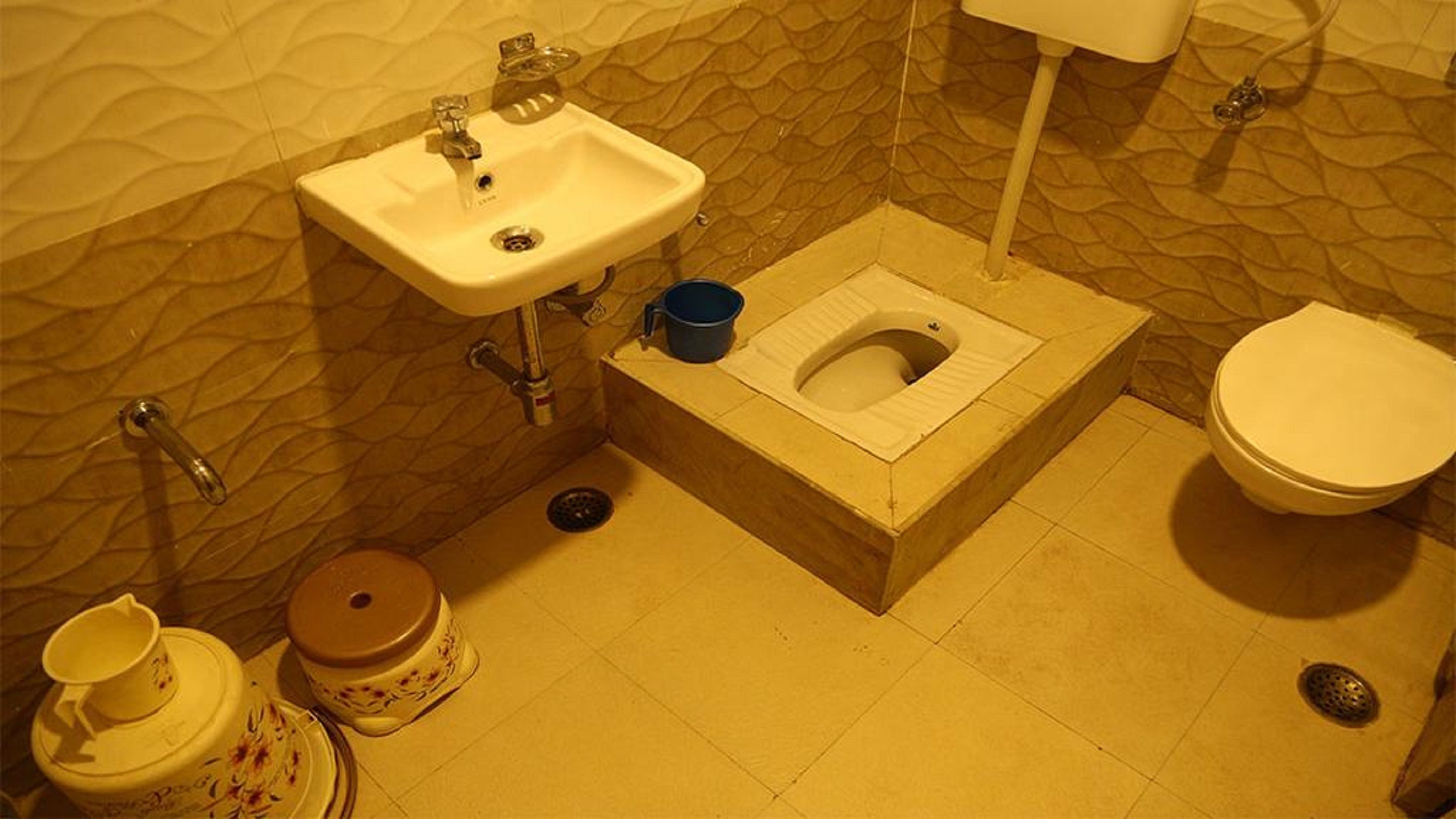 A compact bathroom with a sink, toilet, and bidet.