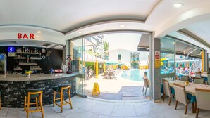 A bar area with a poolside view, including a bar counter, seating, and a pool. - Arsi Enfi City Beach Hotel (Alanya)
