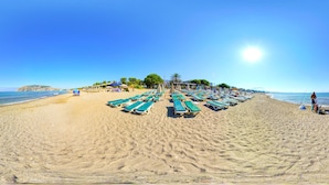 A beach with rows of sun loungers and umbrellas, a clear sky, and a calm sea. - Arsi Enfi City Beach Hotel (Alanya)