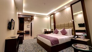A modern hotel room with a large bed, bedside tables, a glass coffee table, and a TV. - The Chinar Resort & Spa, Pahalgam (Anantnag)