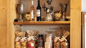 A wooden shelf with various items including bottles, trophies, and wrapped gifts. - Logis Hôtel le Littoral (Evian-les-Bains)
