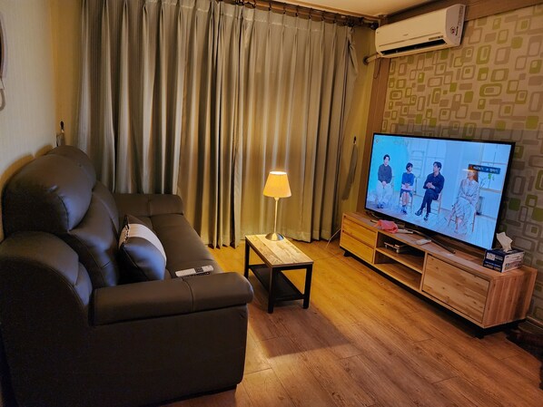 Suite estudio Deluxe, 1 cama Queen size | Área de sala de estar | Televisión de pantalla plana, chimenea y películas con cargo