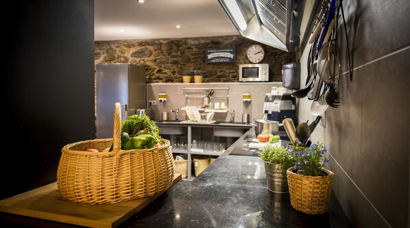 Una cocina moderna con pared de piedra, electrodomésticos de acero inoxidable y encimera de madera.