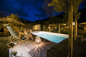 A pool area with lounge chairs and a wooden deck. - Mountain Hostel Tarter (El Tarter)