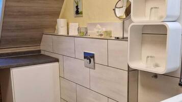 Un bagno moderno con il water, un lavandino e scaffali contenitori.