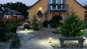 A building with a yellow facade, a balcony with potted plants, and a stone statue in the foreground. - Apartmenthaus in Walle (Schwülper)