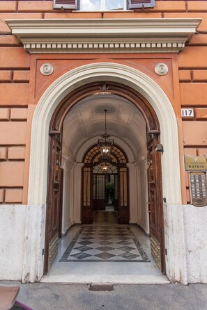 A grand entrance with a marble floor, an arched doorway, and a chandelier. - Lifestyle Veneto Suite (Rome)