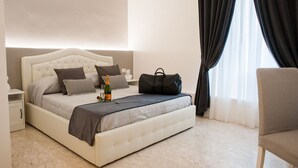 A neatly arranged bedroom with a bed, bedside table, and a chair. - Lifestyle Veneto Suite (Rome)