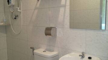 A bathroom with a toilet, sink, towel rack, and a shower head.