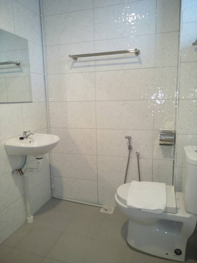 Un baño con lavamanos, inodoro y ducha blancos.