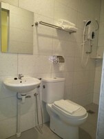 A bathroom with a sink, toilet, and a towel rack.