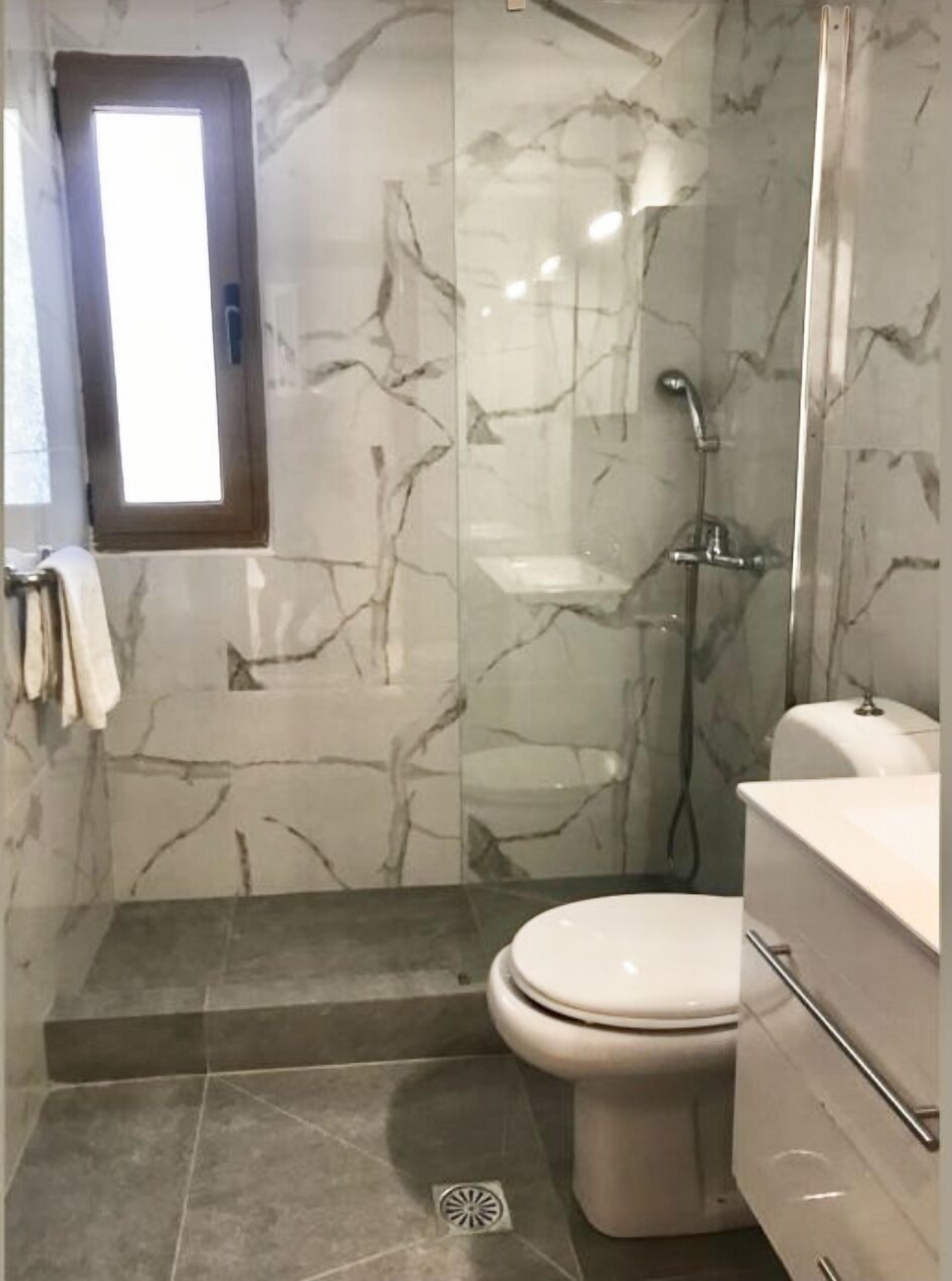 Un bagno con il water, una doccia e un lavandino.