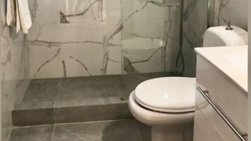 Un bagno con il water, una doccia e un lavandino.