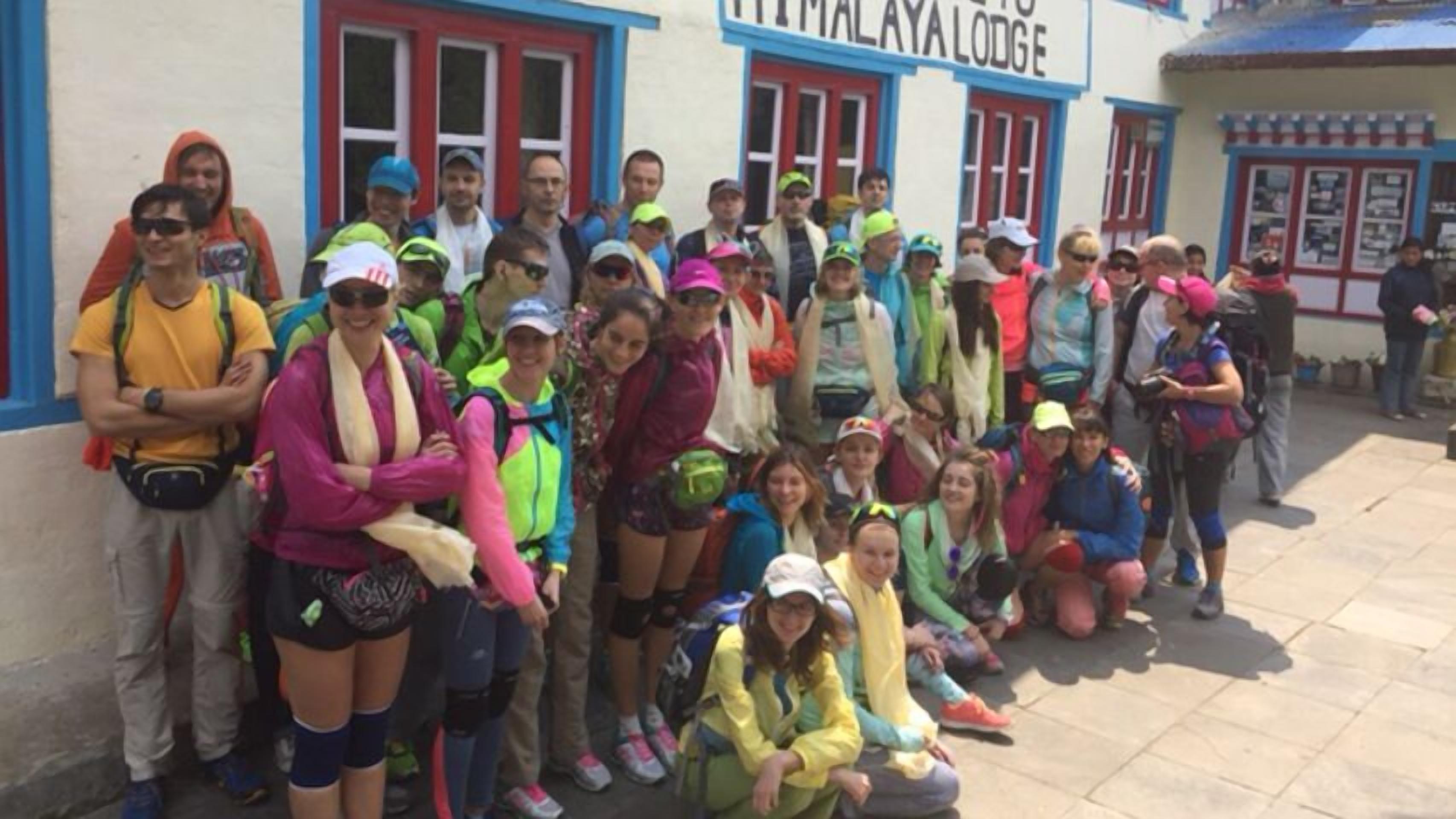 A group of people gathered outside a building with a sign that reads "HIMALAYALODGE".