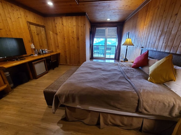 A wooden-paneled bedroom with a bed, a desk, a television, and a view of the outdoors. - Top Cloud Villa (Ren'ai)