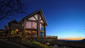 A large, modern house with a prominent balcony and large windows, set against a twilight sky. - Top Cloud Villa (Ren'ai)