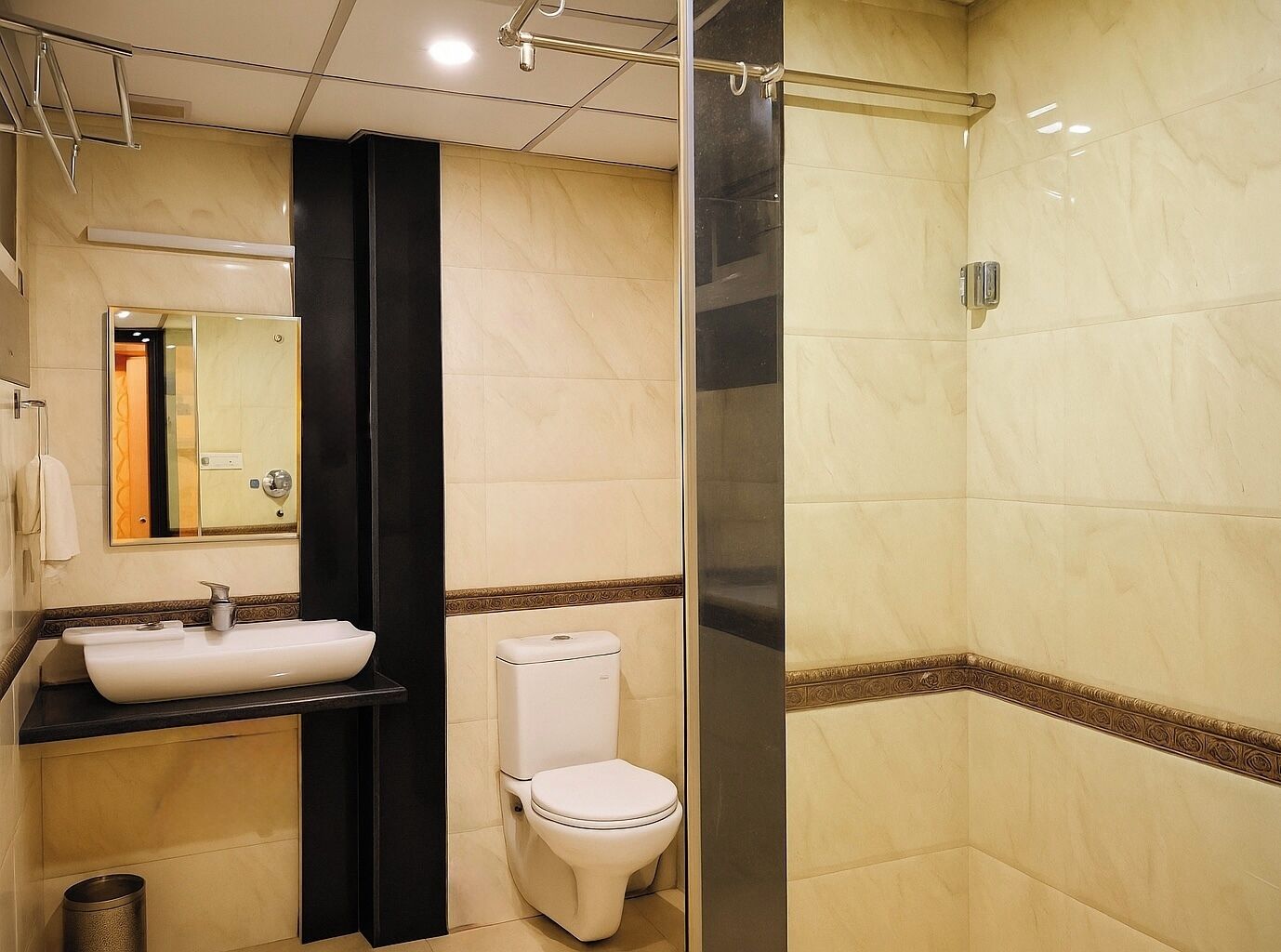 A modern bathroom with a sink, toilet, and glass shower enclosure.