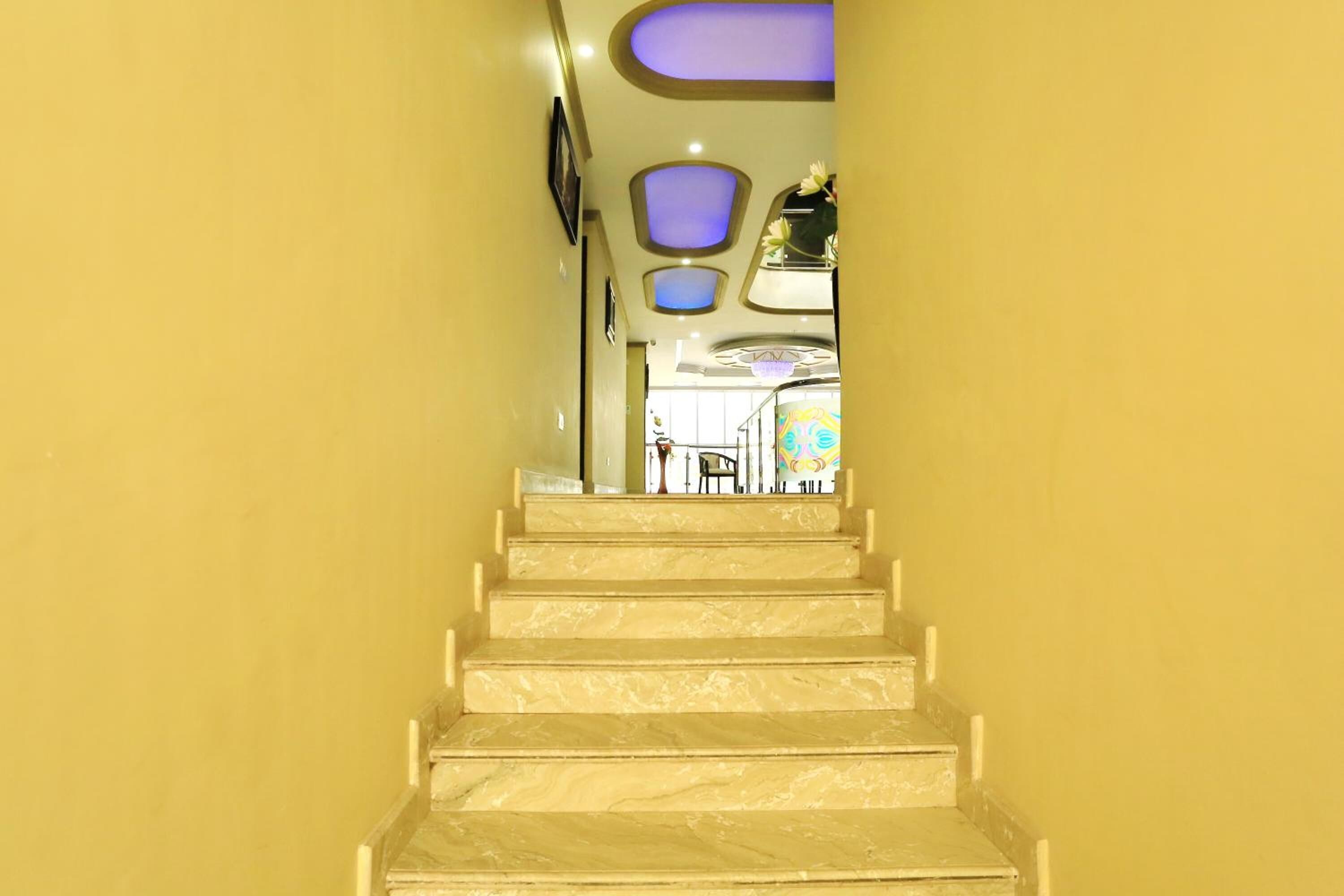 A staircase leading to a room with a view of a dining area.