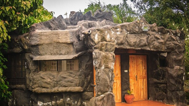 Un edificio rústico de piedra con puerta de madera y una ventana pequeña.