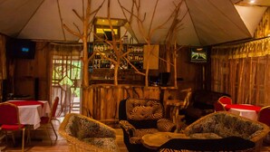 Un restaurante con decoración de madera, sillas con estampado de cebra y una zona de bar.