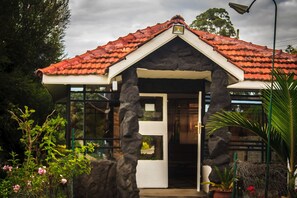 A house with a stone facade, a red-tiled roof, and a glass door. - Brooks Lodge (Gilgil)