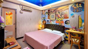 Un dormitorio con una cama, un escritorio y un mural en el techo con personajes de Toy Story.