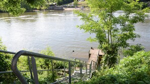 Een rivier met een houten steiger en een metalen reling.