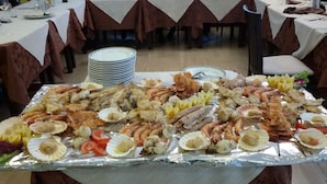 Un bufé de mariscos con una variedad de mariscos y pescados expuestos sobre una mesa.