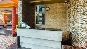 A reception area with a marble counter, a clock, and a 'Rent a Bike' sign. - Hotel de Marina (Port Blair)