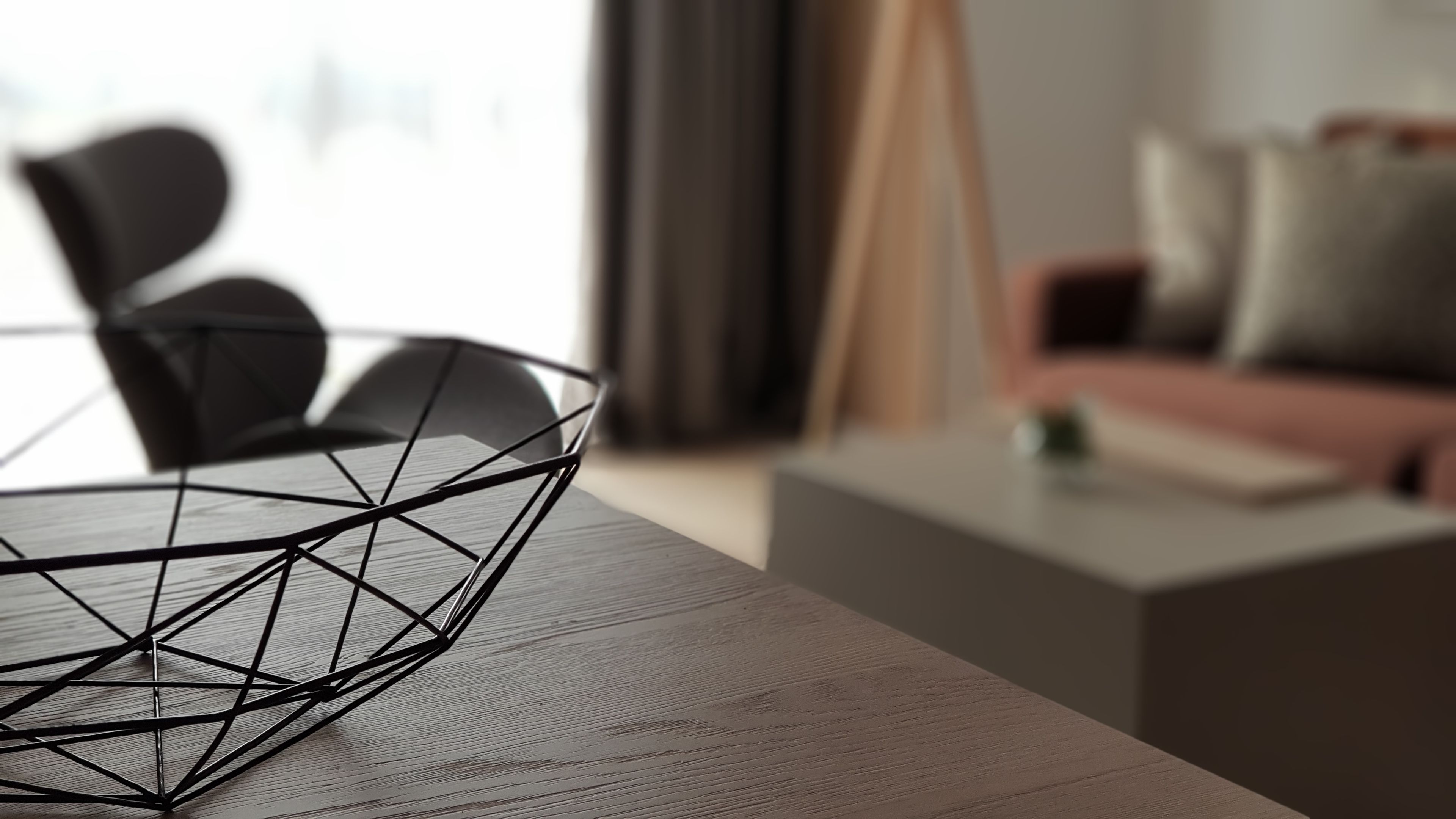 Un espace repas moderne avec une table en verre aux formes géométriques, une table à manger en bois et un canapé en arrière-plan.
