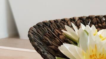 A woven basket with a white flower on a table.