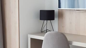 A modern workspace with a desk, chair, and a black lamp.